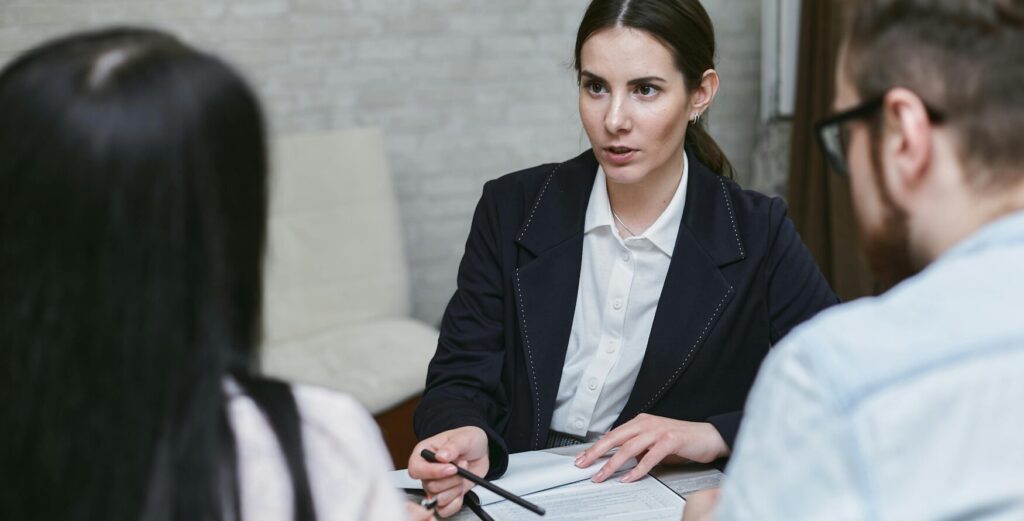 Woman in black blazer talking to her co workers